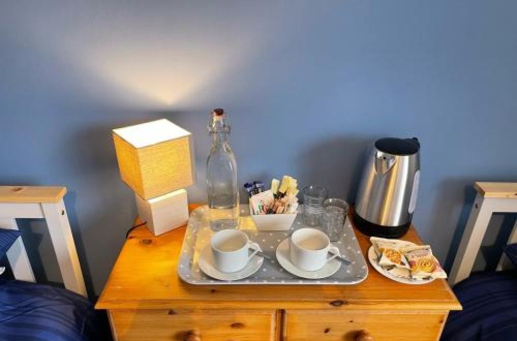Tea tray with kettle and cups on a bedside table